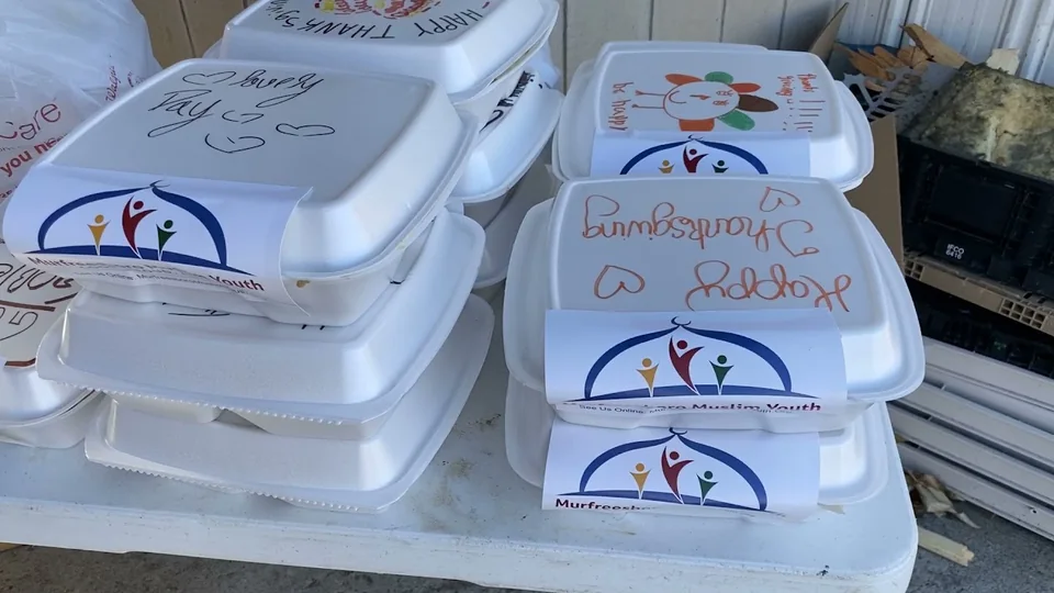 Stacked takeout meal boxes with Murfreesboro Muslim Youth labels and handwritten messages, including “Happy Thanksgiving”