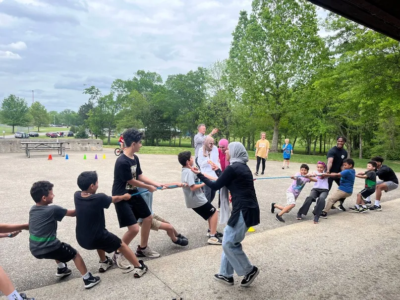 MMY Boys' Club members playing tug-of-war outdoors