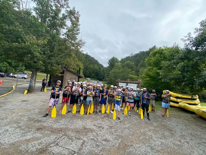 A large group of MMY youth with paddles before a rafting trip