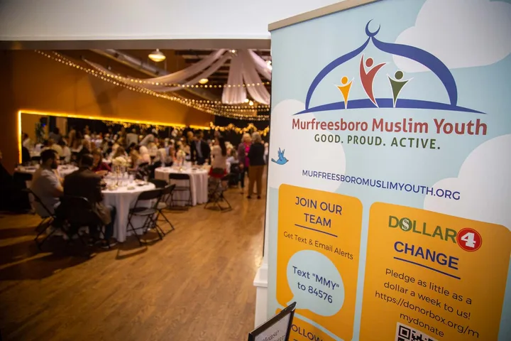 An MMY banner in the foreground of a community banquet